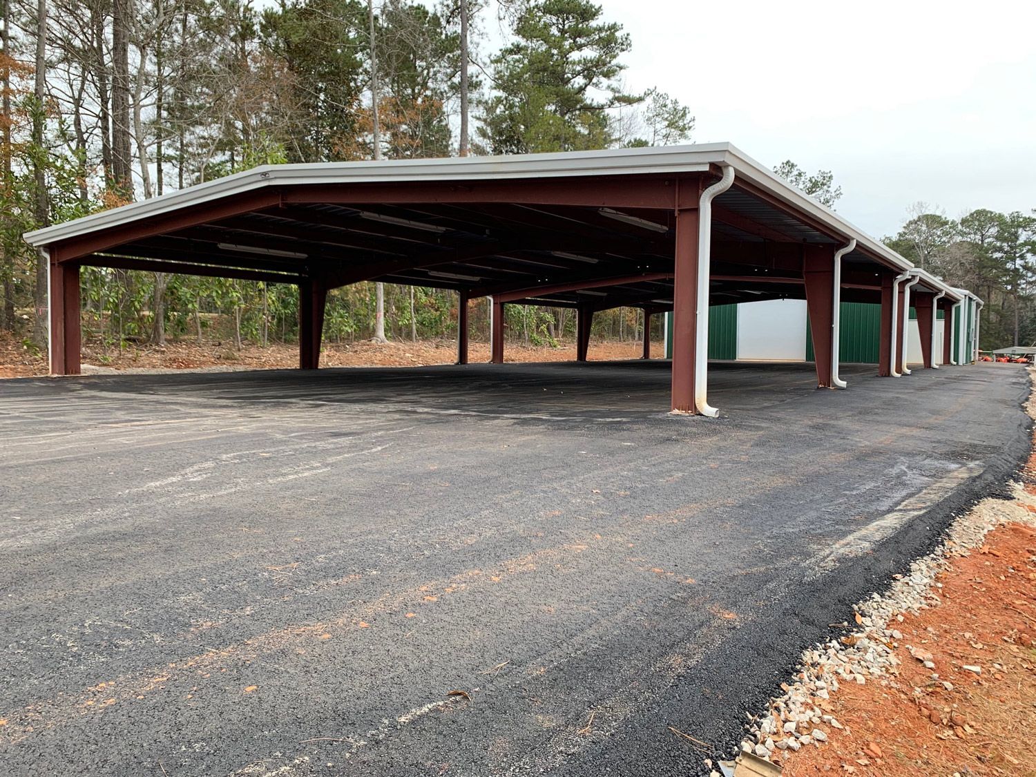 A row of carports are lined up on the side of a road.