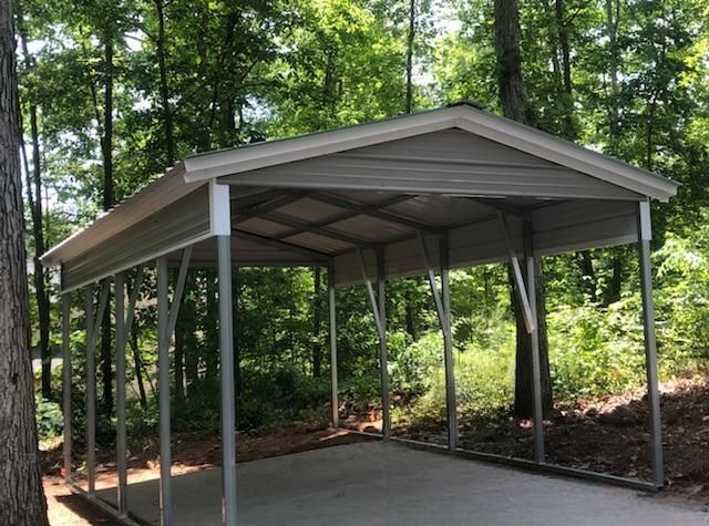 A carport in the middle of a forest with trees in the background