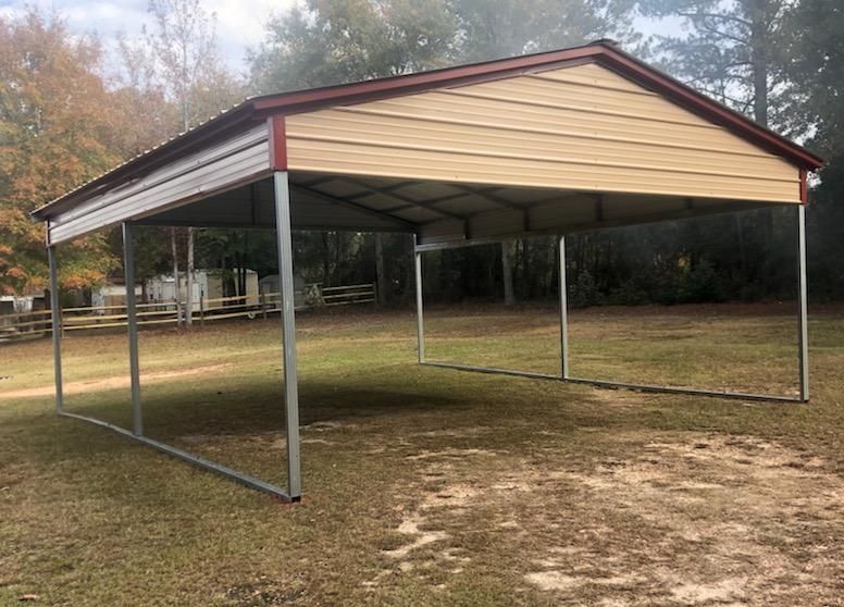A carport is sitting in the middle of a grassy field.