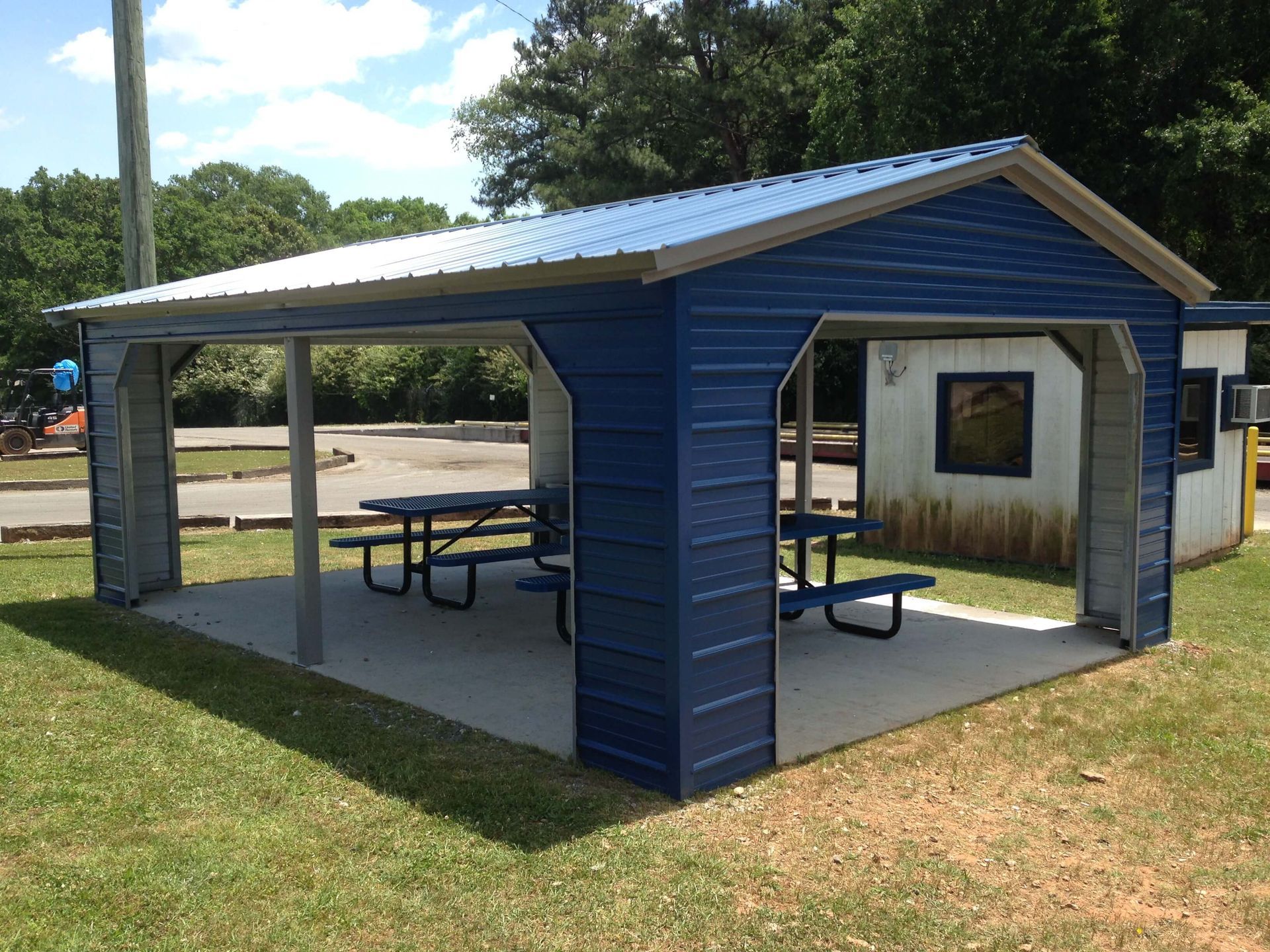A blue pavilion with a picnic table inside of it