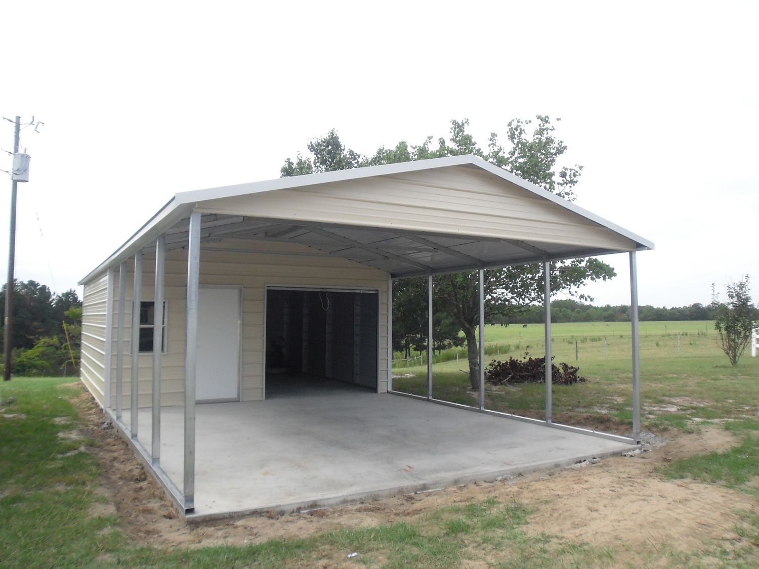 A garage with a carport attached to it in a field.