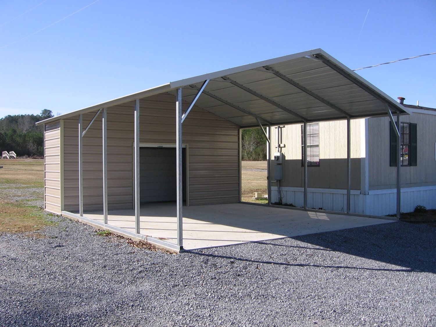 A mobile home with a carport in front of it