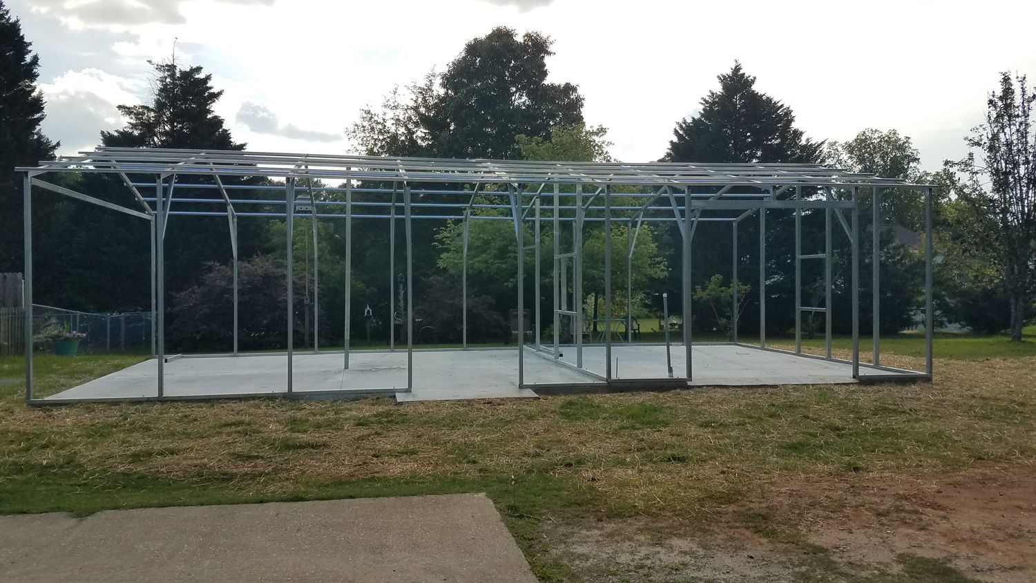 A large metal structure is sitting in the middle of a grassy field.