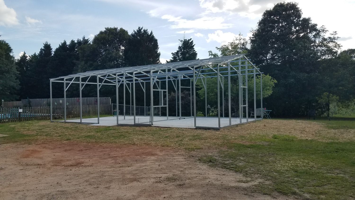 A large metal structure is being built in the middle of a dirt field.