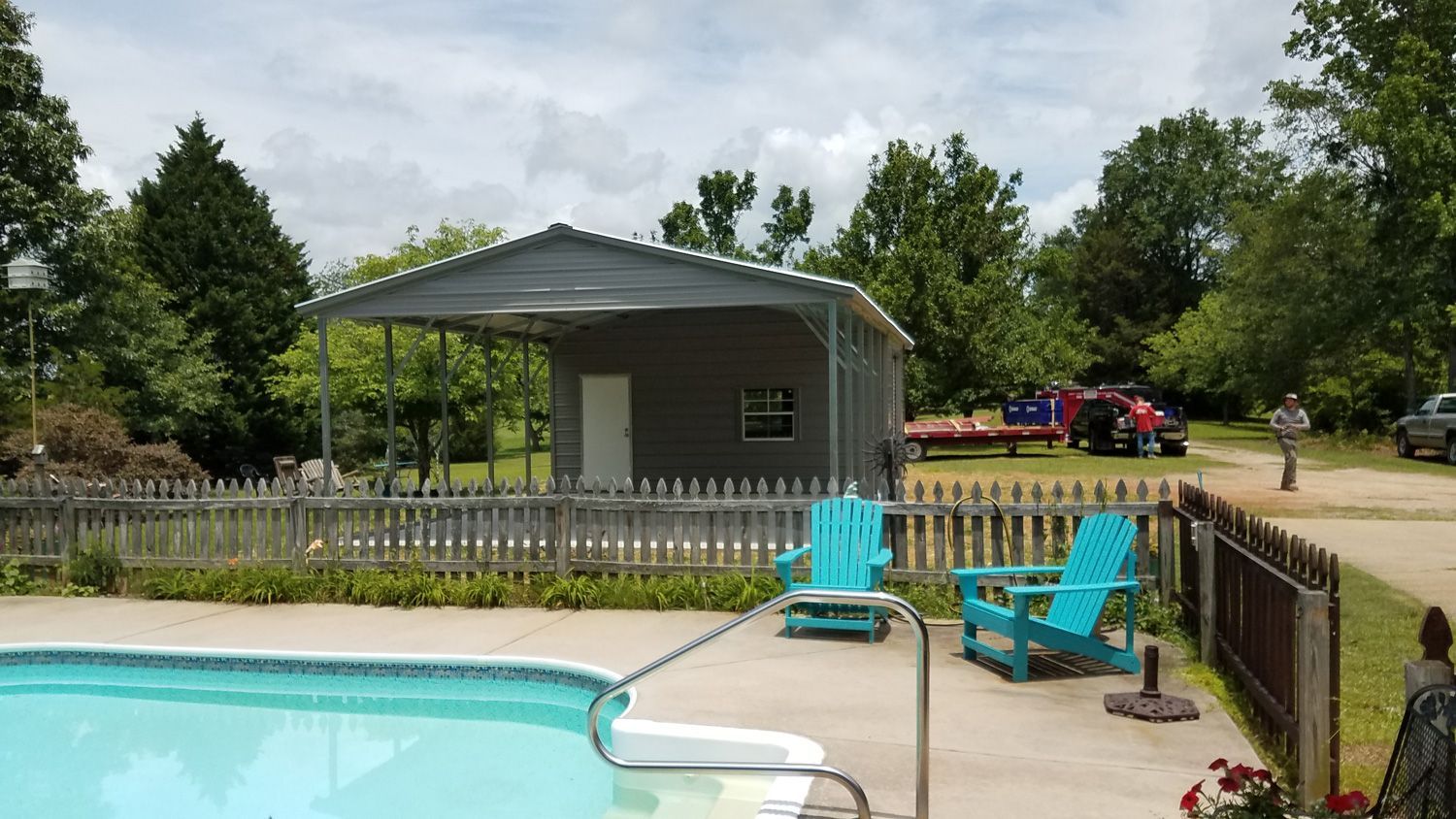 There is a swimming pool in the backyard of a house.