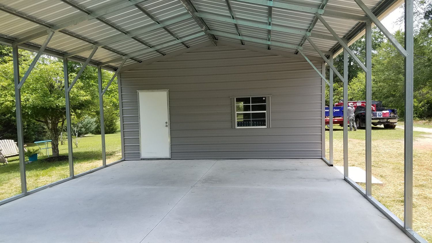 There is a carport with a window and a door.