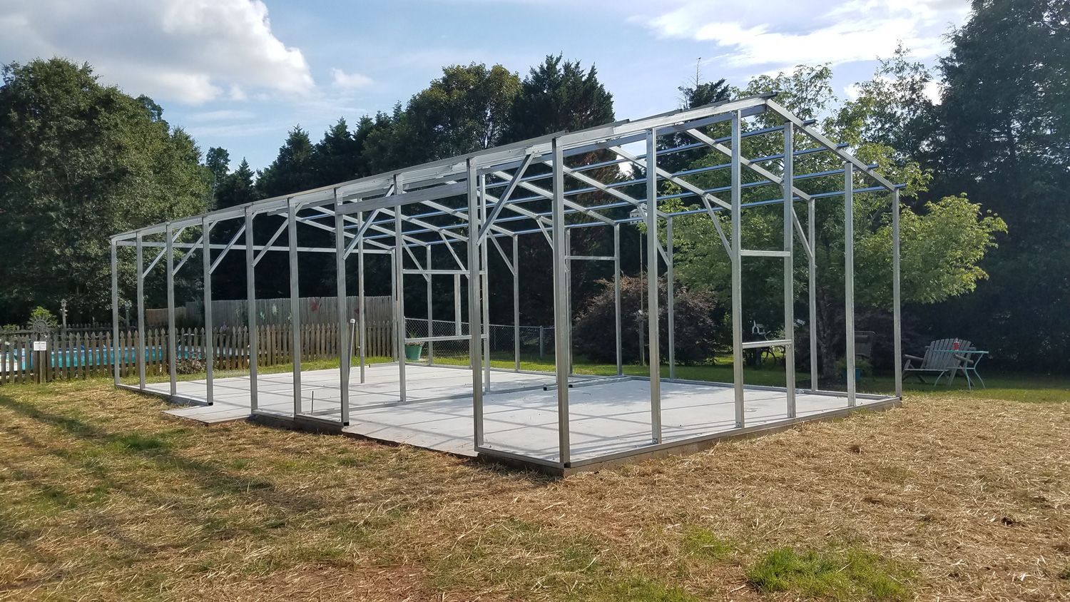 A large metal structure is sitting in the middle of a field.
