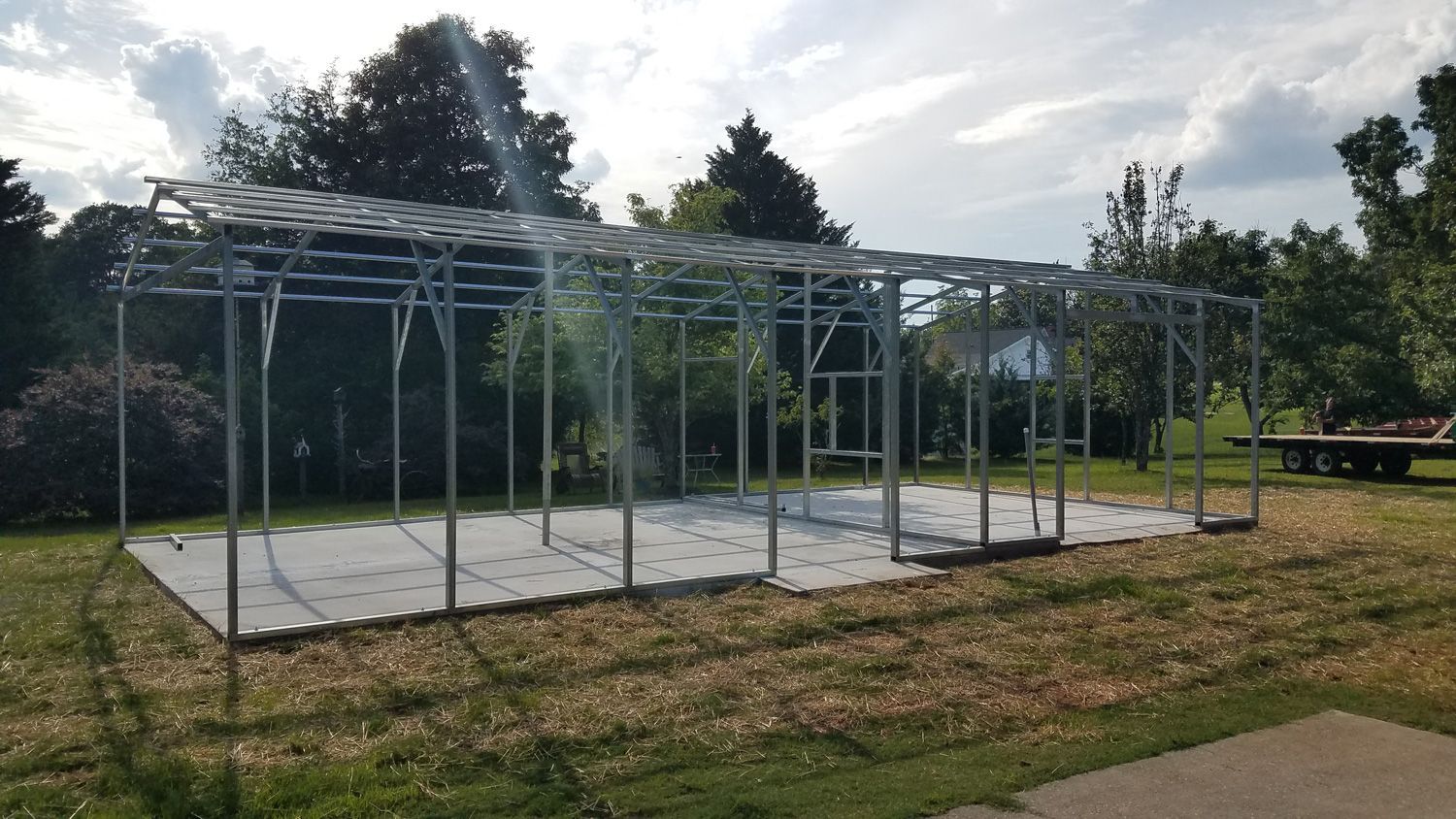 A large metal structure is sitting in the middle of a grassy field.