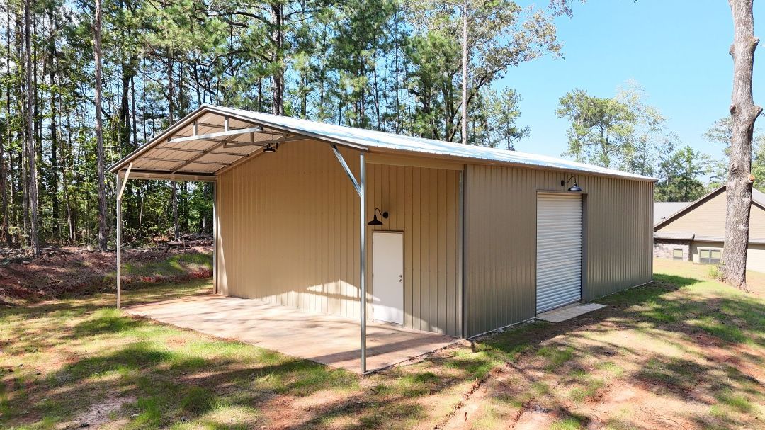 A metal building with a canopy on top of it in the middle of a field.