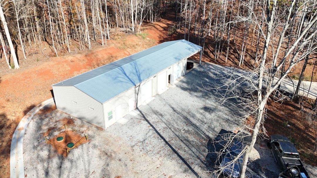 An aerial view of a garage in the middle of a forest.