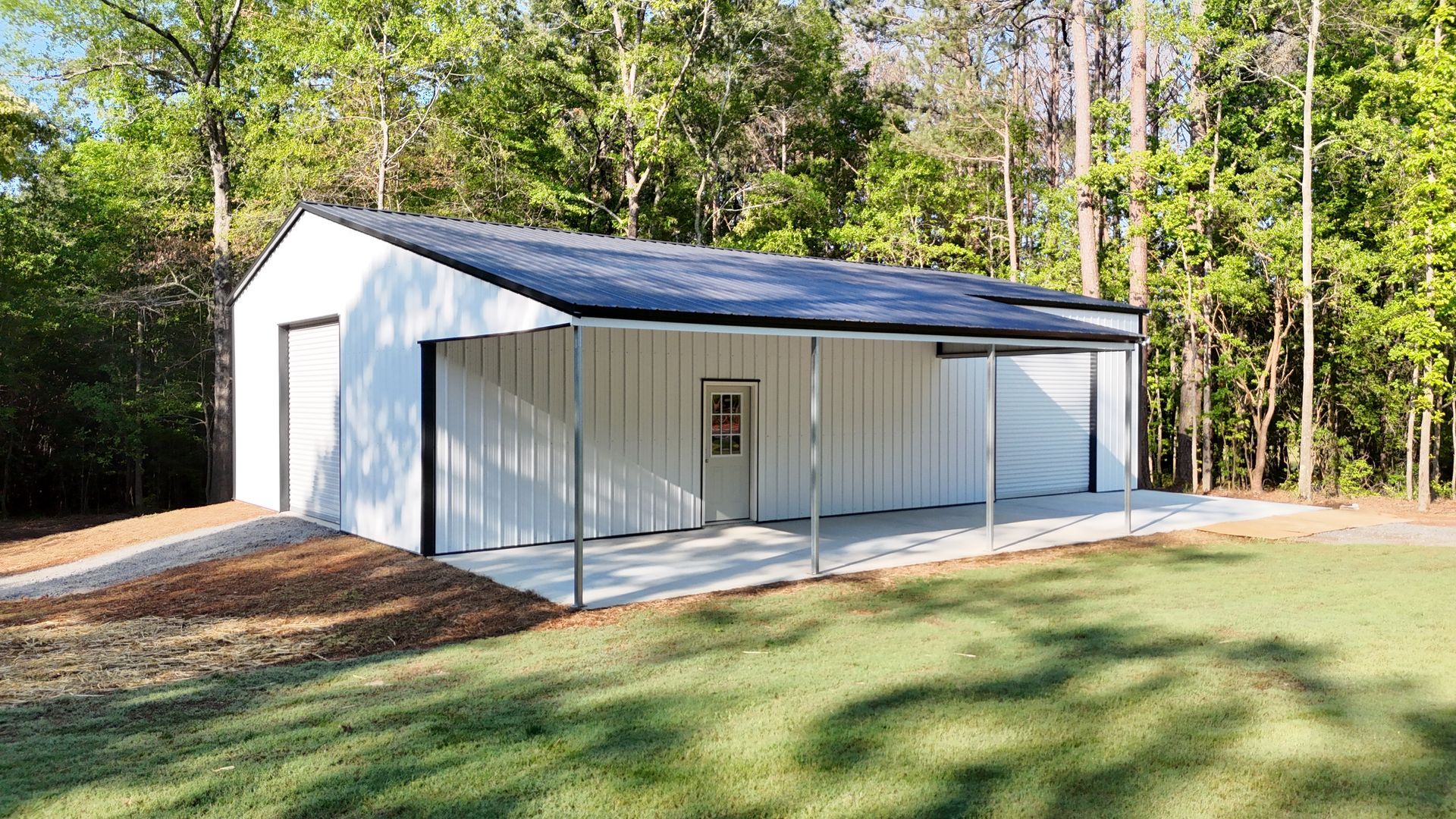 A white garage with a porch and trees in the background.