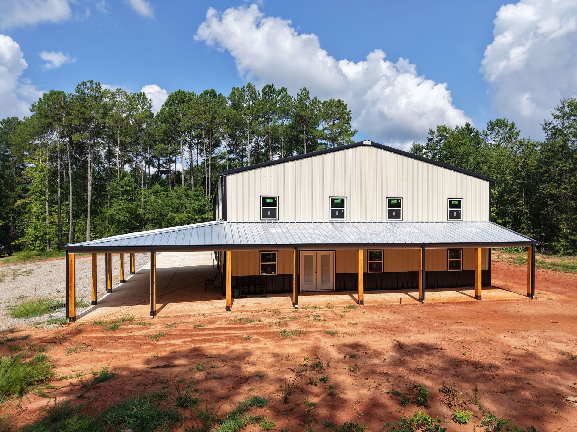 A large building with a porch and trees in the background
