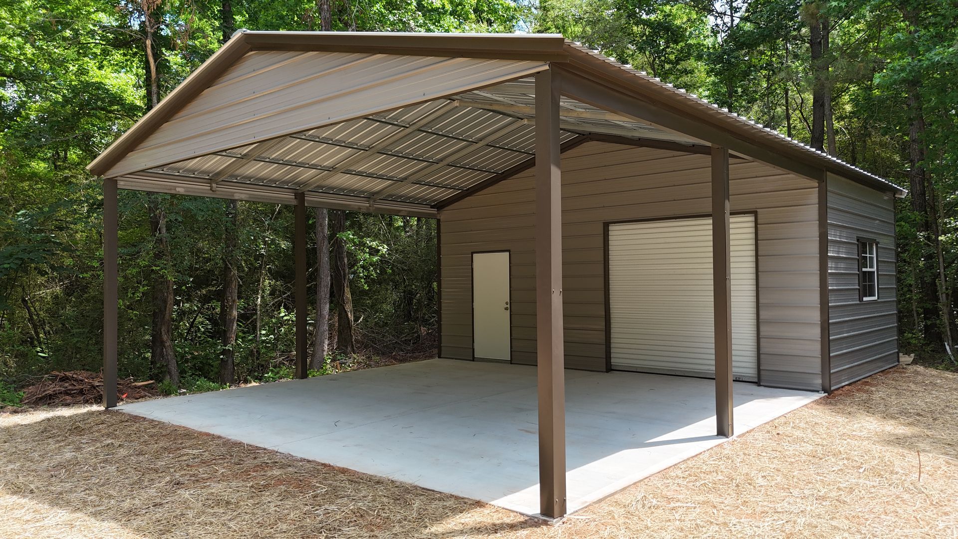 Covered carport beside a small shed in a wooded area, with a concrete slab and open front.