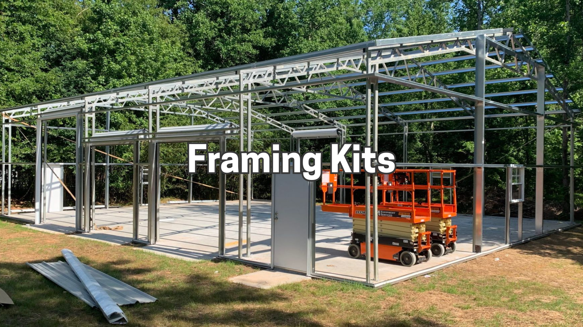 Steel building frame kit under construction with orange lift, overlaid text “Framing Kits”