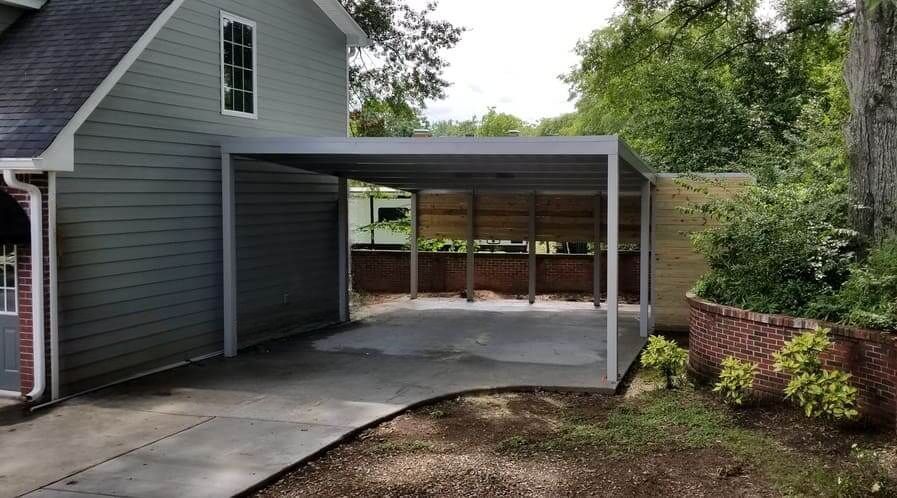 A carport is attached to the side of a house.