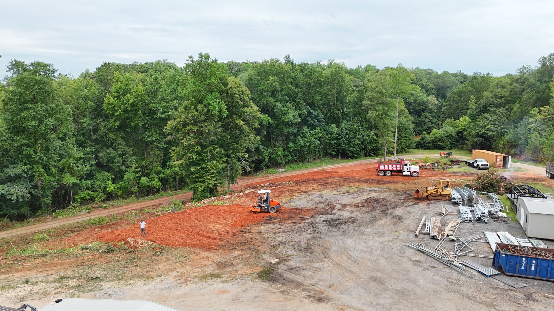 An aerial view of a construction site with trees in the background.