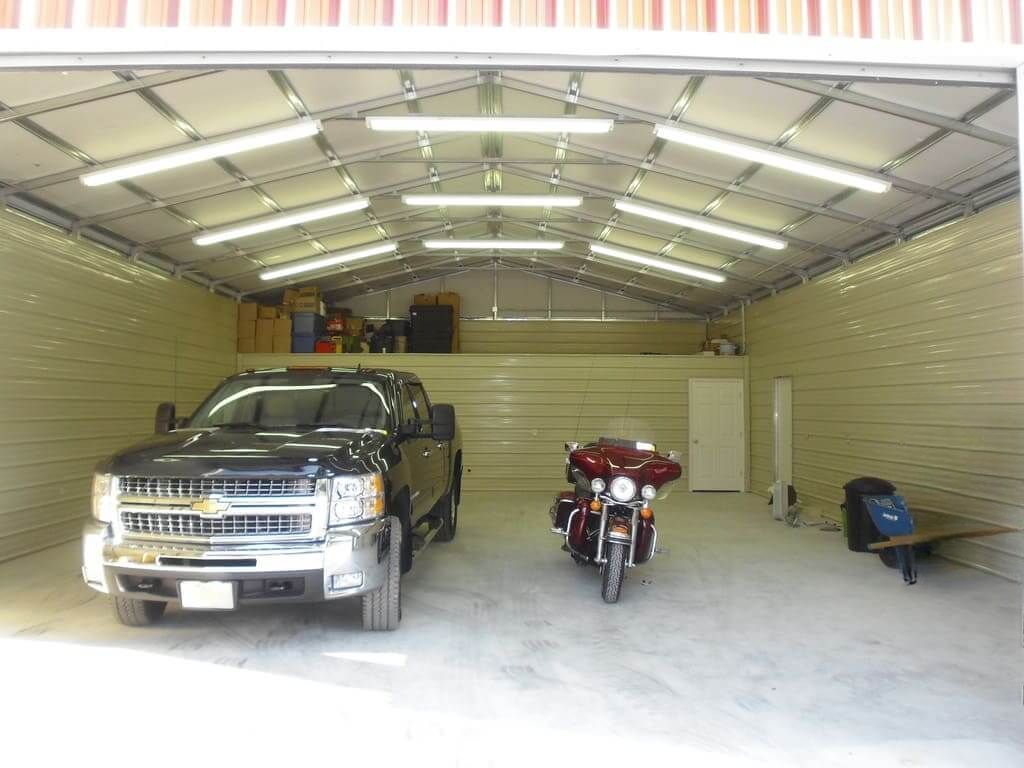 A truck and a motorcycle are parked in a garage