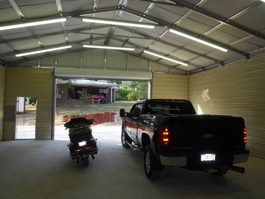 A truck and a motorcycle are parked in a garage