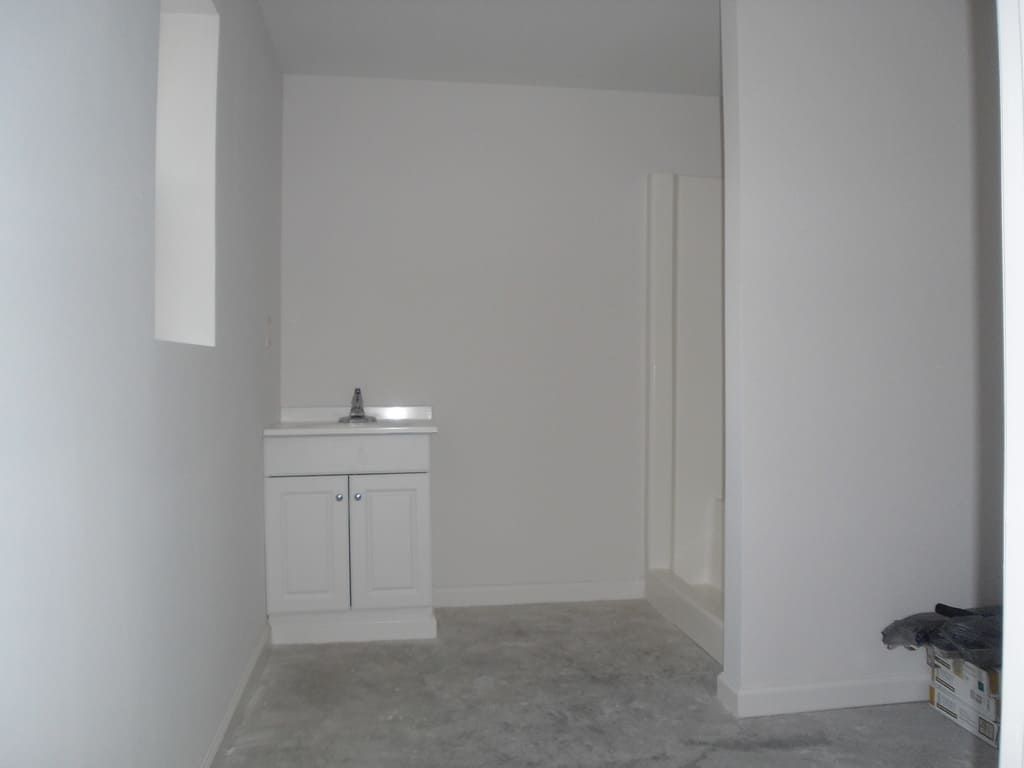 An empty room with a sink and a window