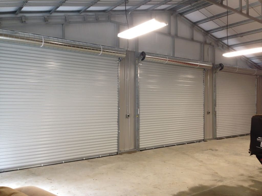 A truck is parked in a garage with a lot of white garage doors.