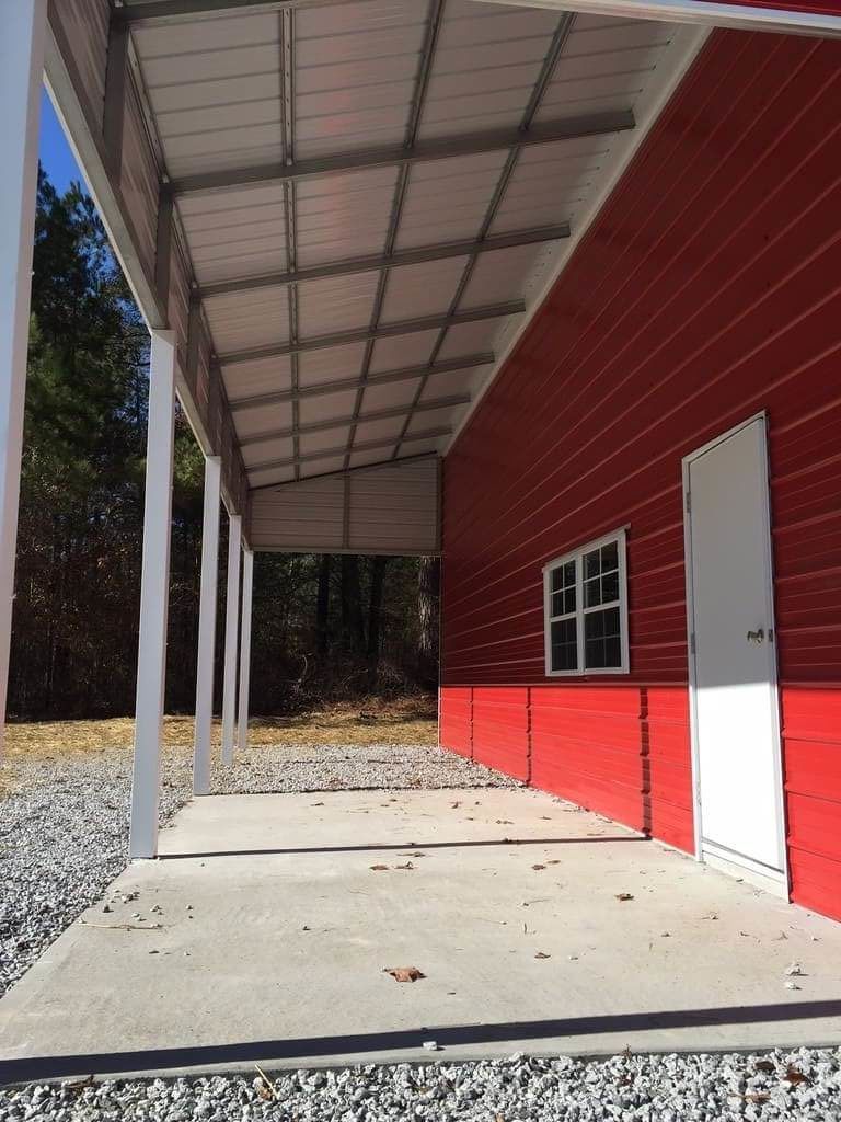 A red building with a covered porch and a white door.