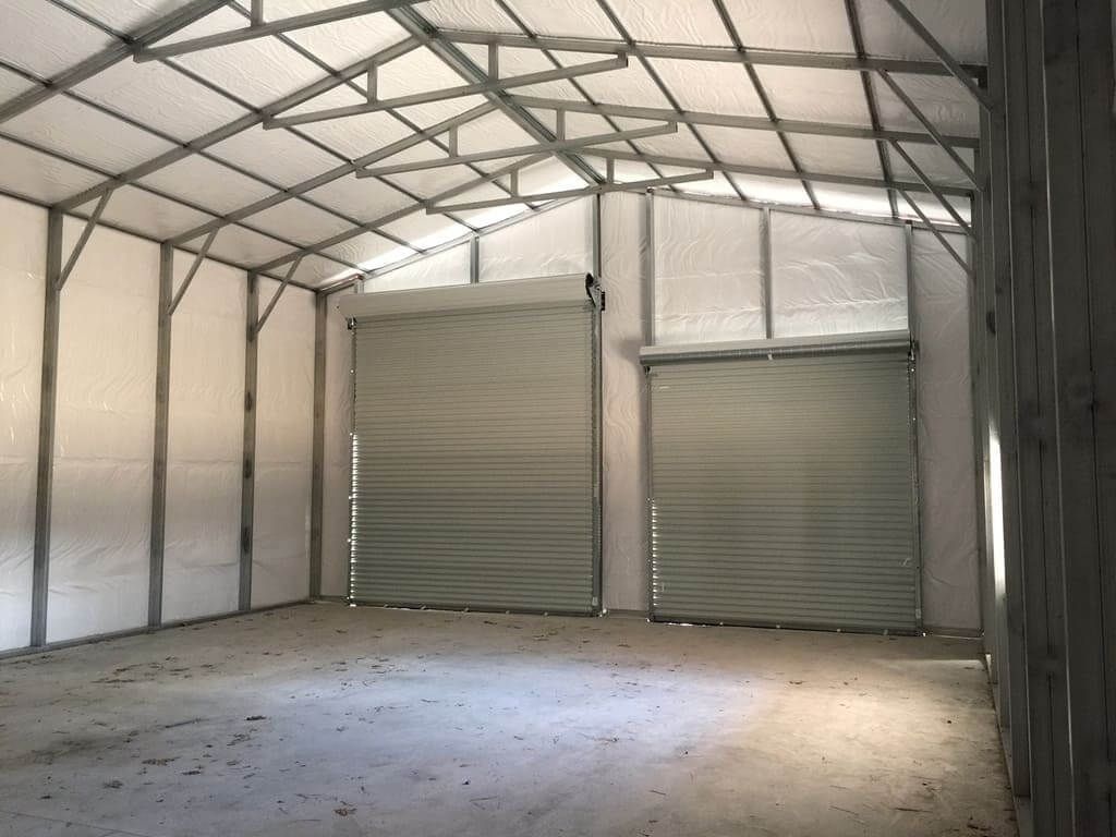 A large empty warehouse with two garage doors.