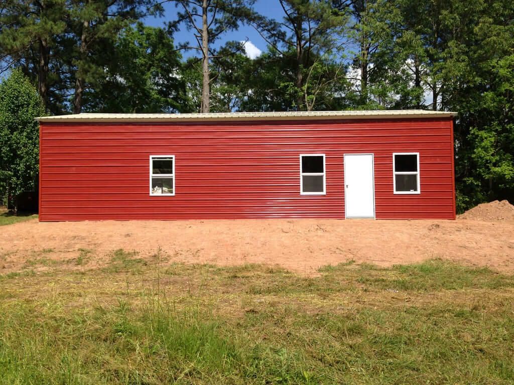A red building with white windows and a white door
