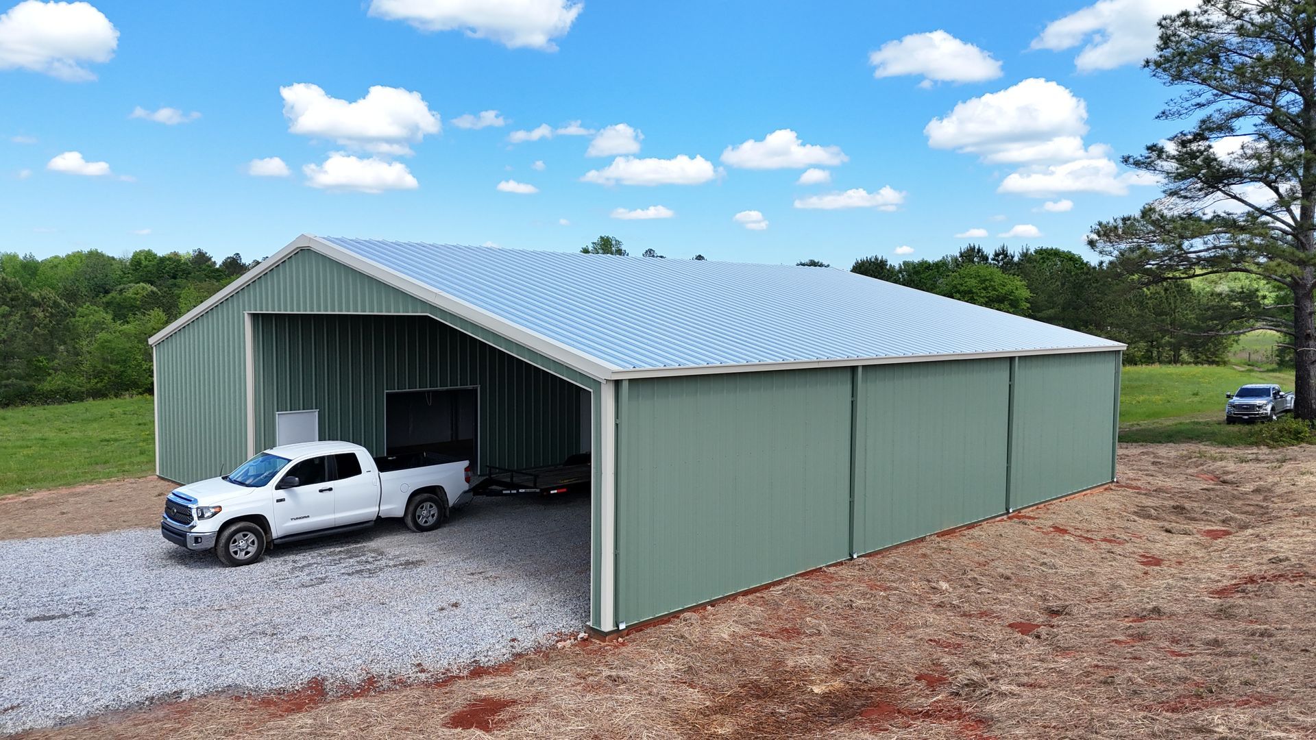A white truck is parked in a metal garage.