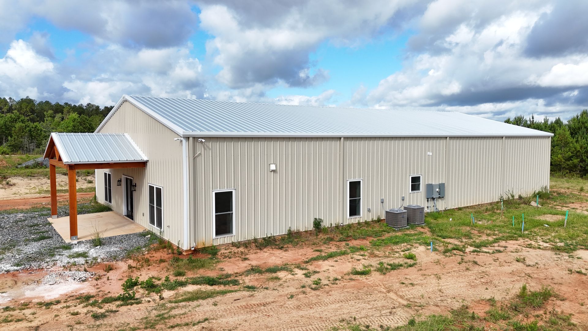 A large metal building is sitting in the middle of a field.