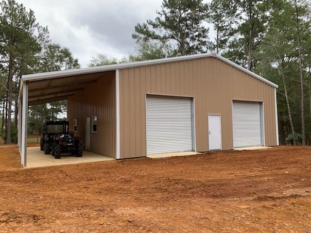 A jeep is parked in the garage of a metal building.