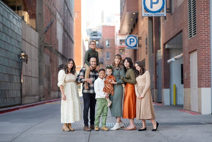 A family is posing for a picture while sitting on a couch.