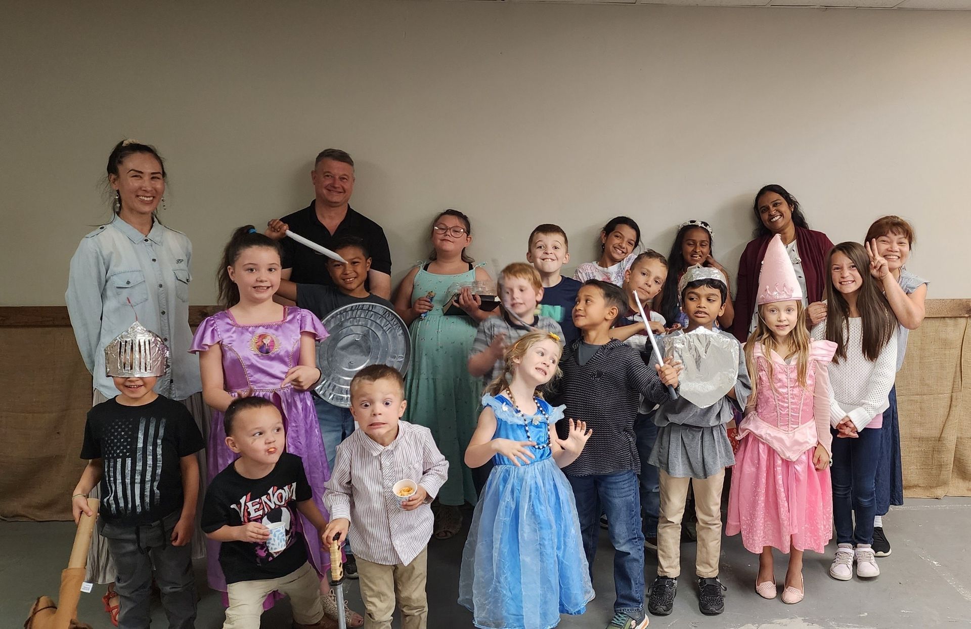 A group of children dressed in costumes are posing for a picture.