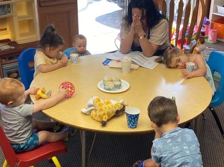 A group of children are sitting around a round table