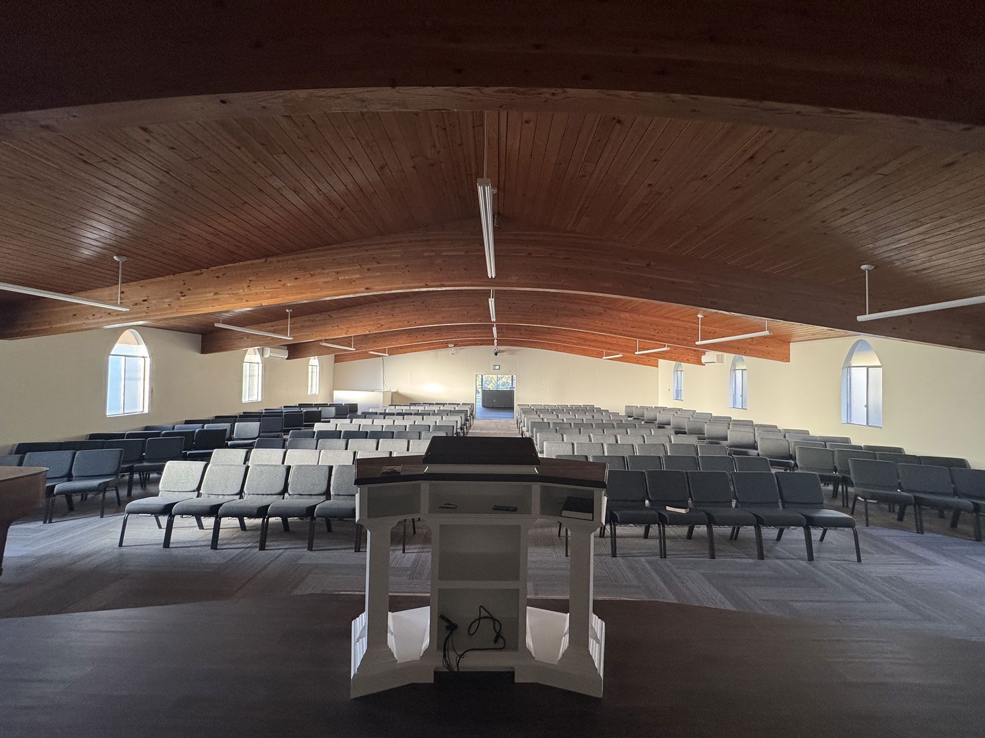 An empty church with rows of chairs and a podium