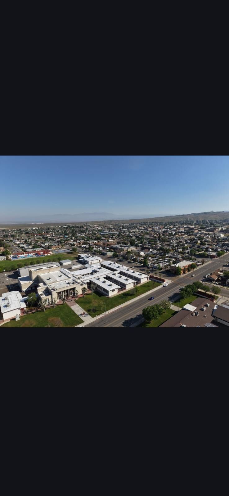 Aerial view of a sprawling suburban neighborhood under a clear blue sky.