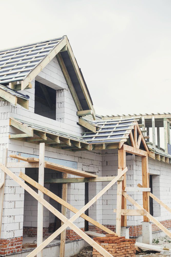 Partially built house with wooden framing and roof under construction