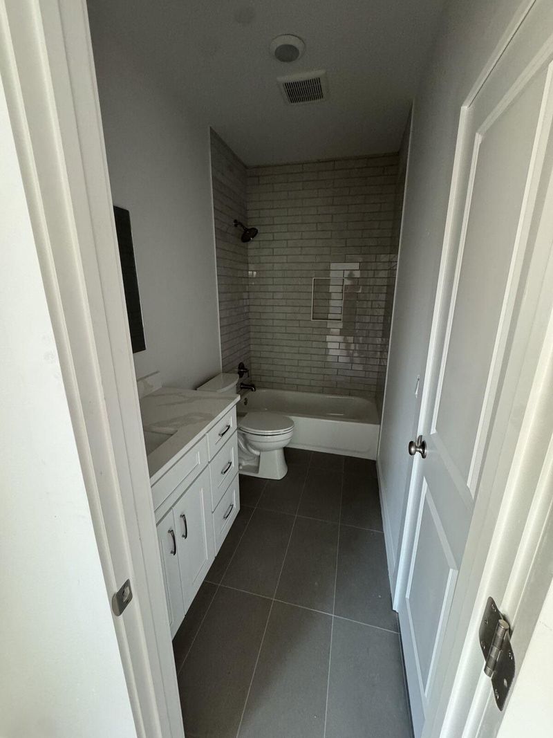 Guest bathroom remodel with subway tile tub surround and white vanity