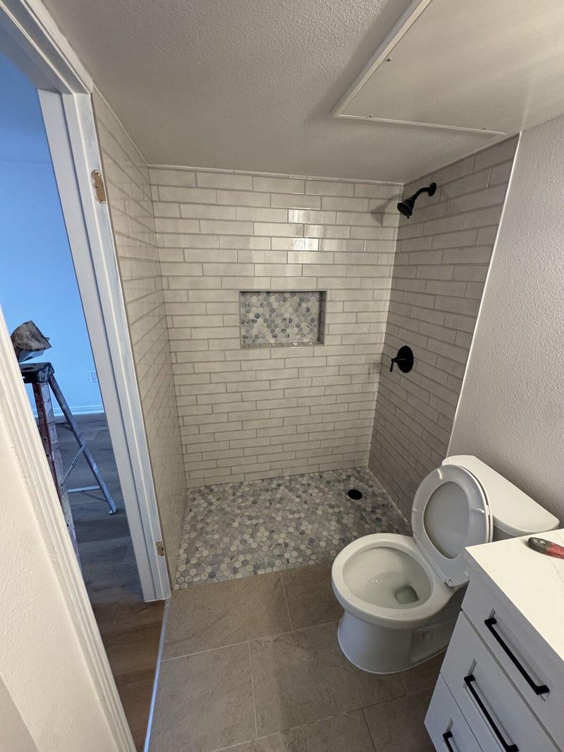 Bathroom remodel with subway tile shower and pebble tile pan