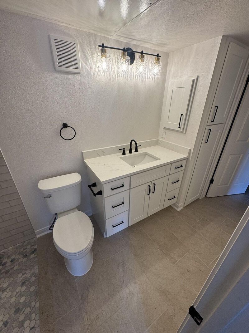 Completed bathroom vanity with quartz countertop and black hardware