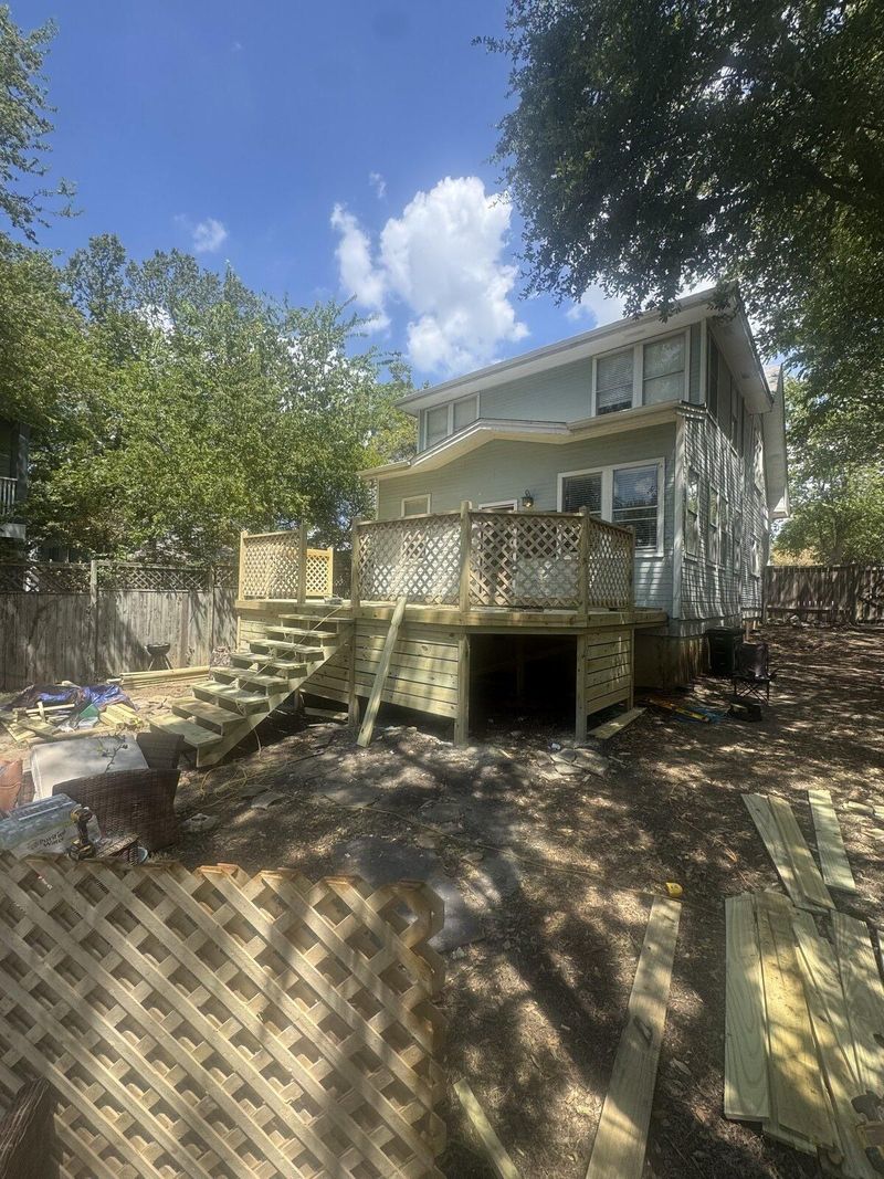 Finished deck with lattice railing and stairs at a completed renovation