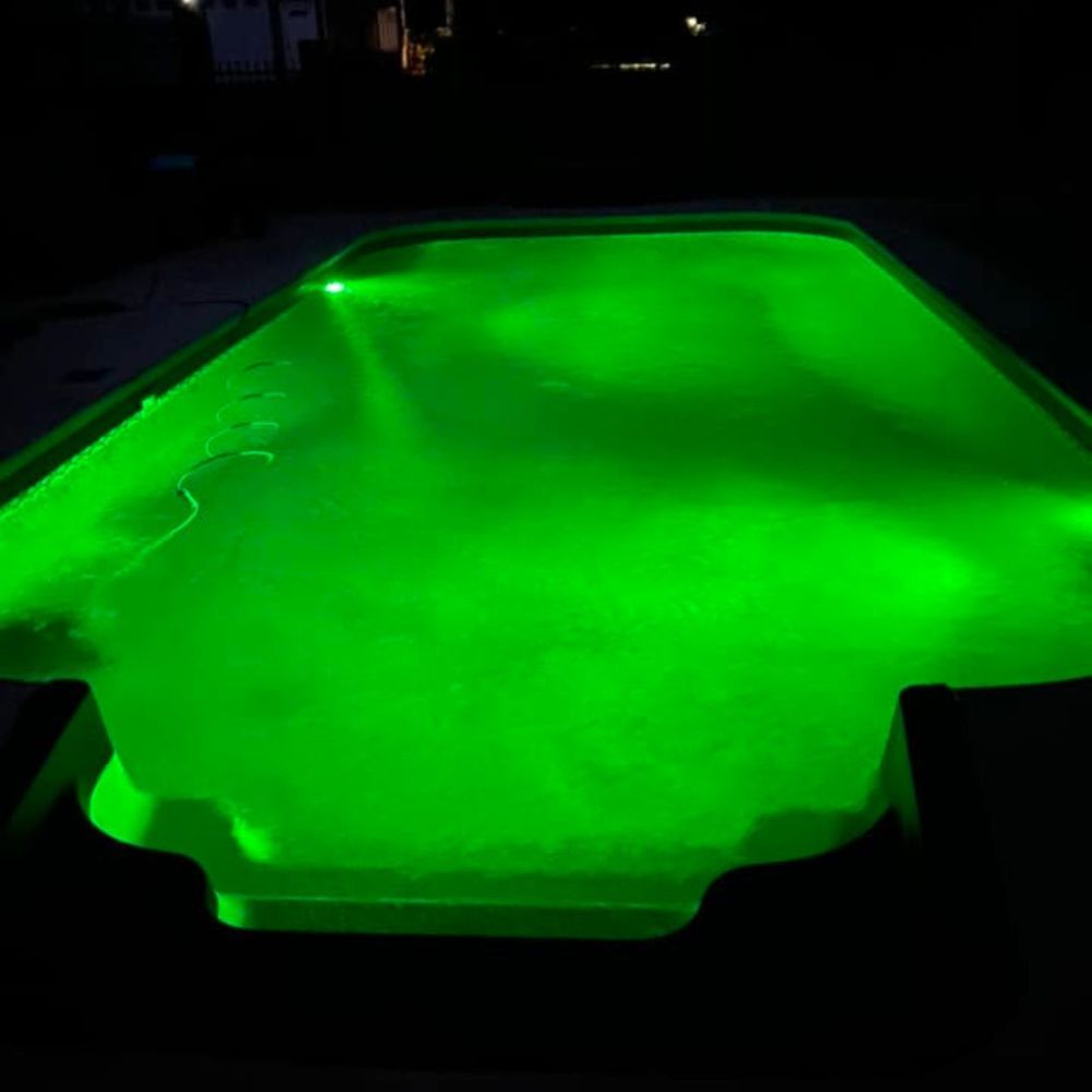 Glowing green-lit pool at night, viewed from above