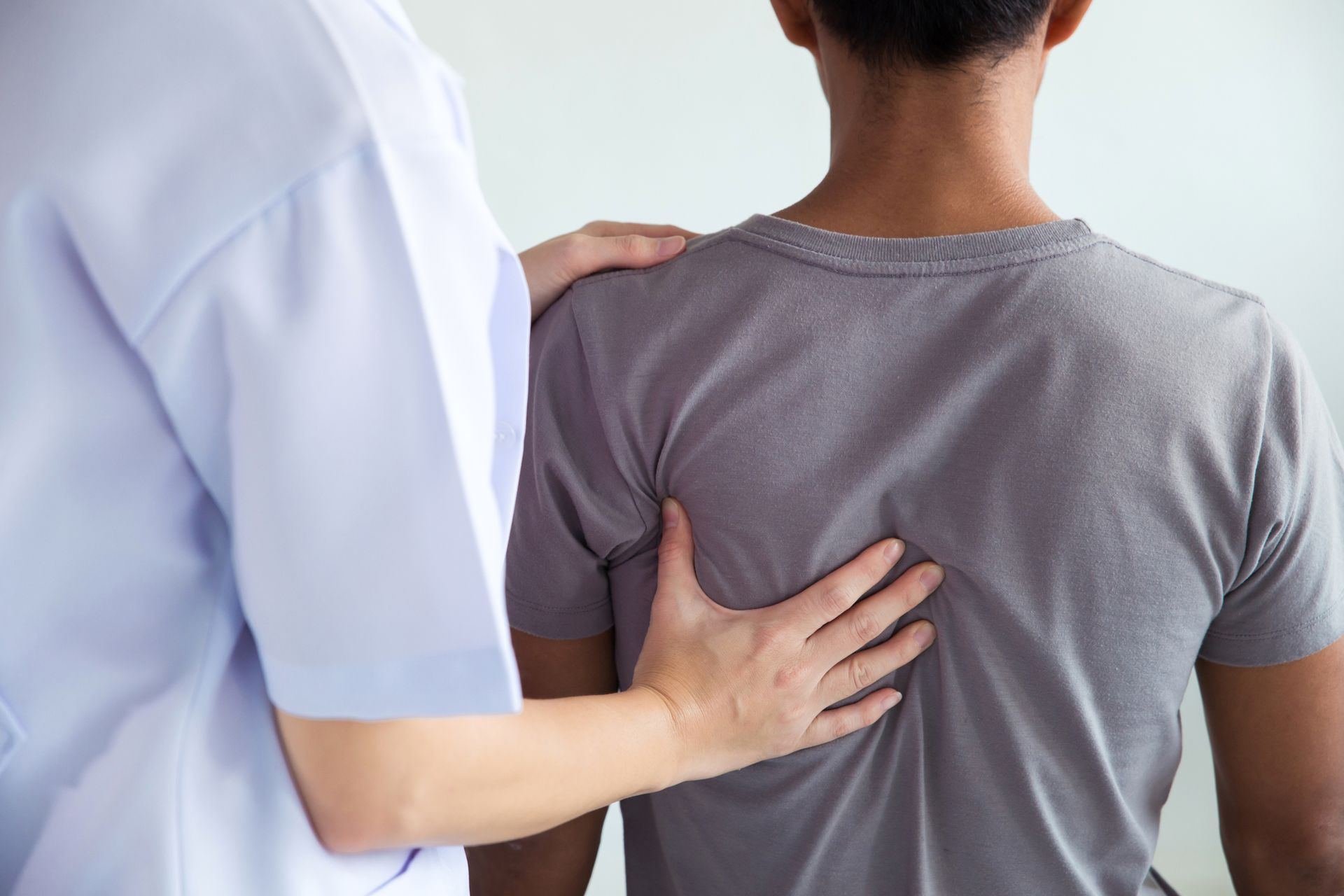 Chiropractor evaluating and treating a man’s back during physical therapy session.