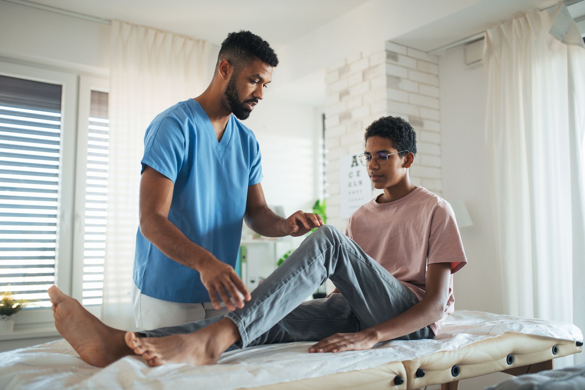 A male chiropractor is treating knee pain.