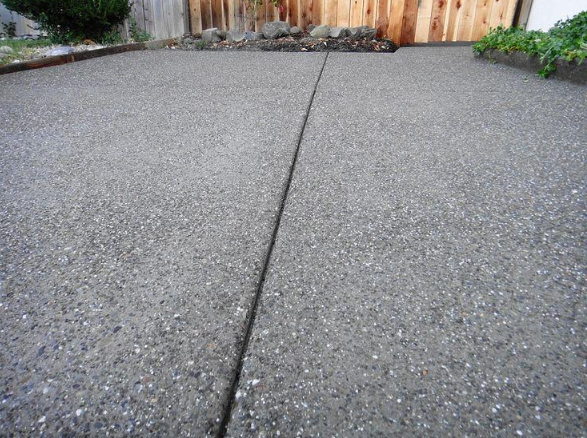 “Close-up of a textured concrete driveway surface with a neat expansion joint by a concrete contractor in Casas Adobes, AZ”