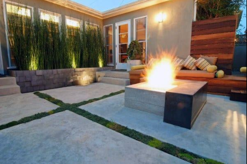 “Modern backyard concrete patio with a square fire feature, seating area, and privacy fence by a concrete contractor in Casas Adobes, AZ”