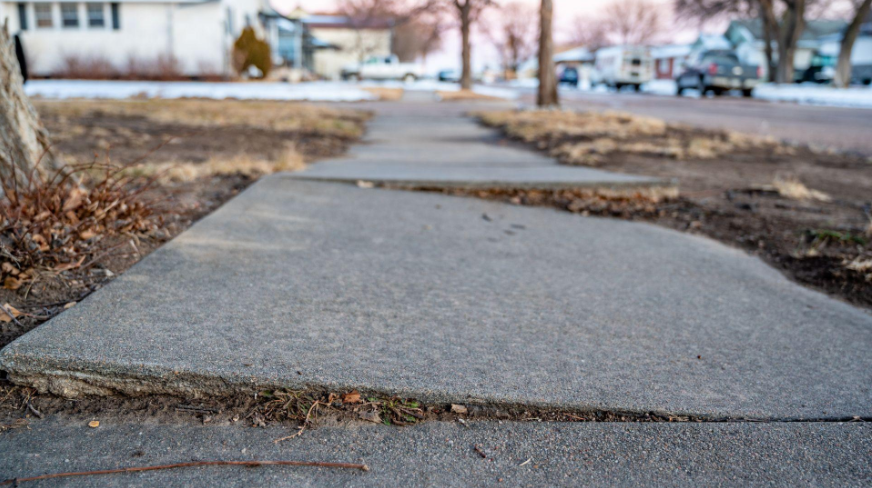 “Cracked and uneven outdoor concrete walkway showing damage before repair by a concrete contractor in Casas Adobes, AZ”