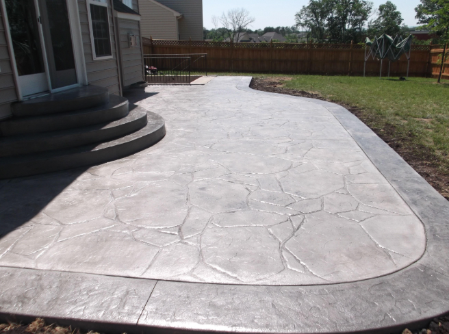 “Backyard stamped concrete patio with decorative texture and open space near the home by a concrete contractor in Casas Adobes, AZ”