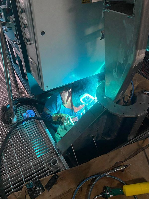 Man is Welding Under a Machine in a Factory — BME NQ in Portsmith, QLD
