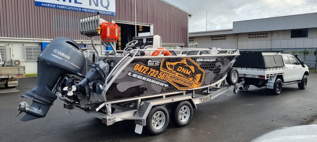 A boat is being towed by a truck on a trailer.