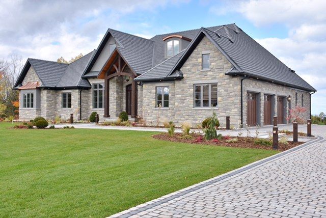 A large house with a brick driveway leading to it.